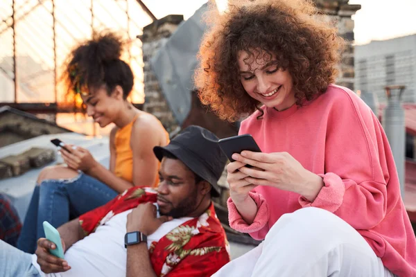 Joyeux jeunes amis s'amuser avec des smartphones en plein air — Photo