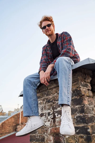 Happy handsome guy sitting on roof alone — Stock Photo, Image