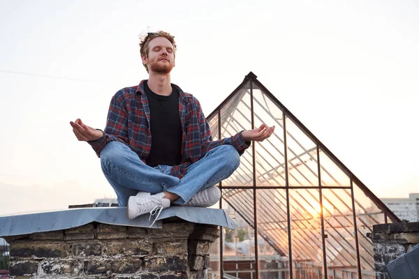 Lugn stilig man gör meditation på taket — Stockfoto