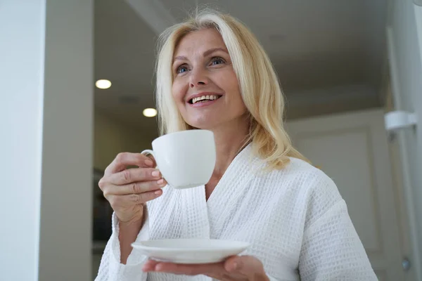 Smiling pretty woman wearing white bathrobe in spa salon — Stock Photo, Image