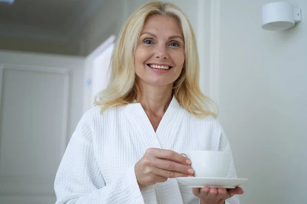 Happy pretty lady wearing white bathrobe in spa salon — Stock Photo, Image