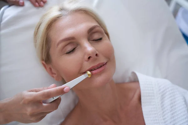 Tapasztalt kozmetikus eszköz segítségével javítja a bőr közelében az ajkak — Stock Fotó