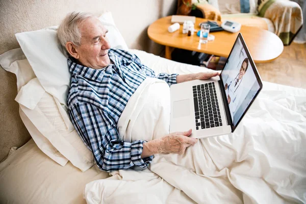 Senior man surfing the Internet on laptop