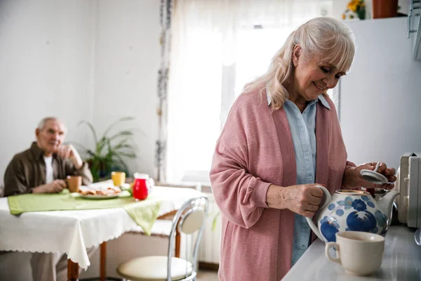 Frau schenkt ihrem Mann Tee ein — Stockfoto