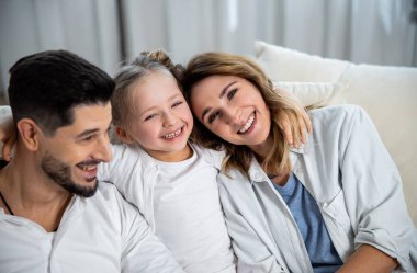 Ebeveynler ve onların tatlı küçük kızları sarılıyorlar.