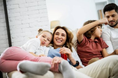 Aile kanepede otururken aylaklık ediyor.