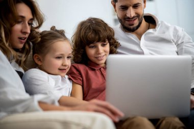 Aile laptopta bir şeye bakıyor.