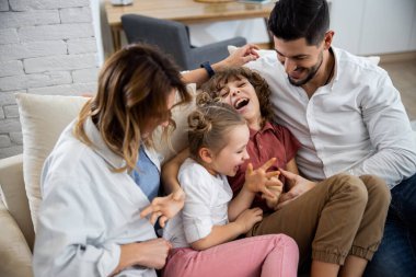 Aile kanepede otururken aylaklık ediyor.