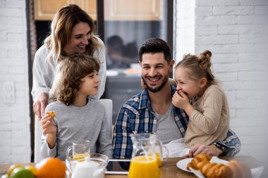 Mutlu bir aile birlikte kahvaltı yapıyor.