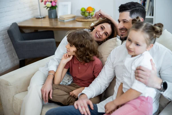 Perhe halaus sohvalla — kuvapankkivalokuva