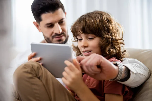 Pai e filho usando tablet na sala de estar — Fotografia de Stock