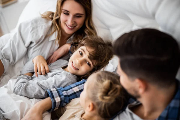 Дети с родителями просыпаются в постели — стоковое фото