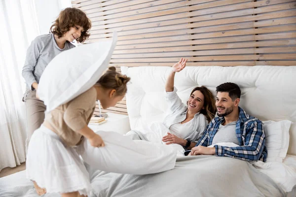 Niños felices con los padres teniendo pelea de almohadas — Foto de Stock