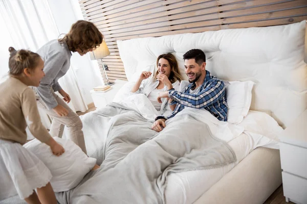 Семья веселится со своими детьми на кровати — стоковое фото