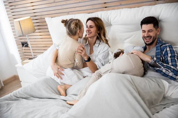 Los padres riendo mientras están acostados en la cama —  Fotos de Stock