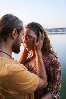 Erkek kız arkadaşına sarılıyor.