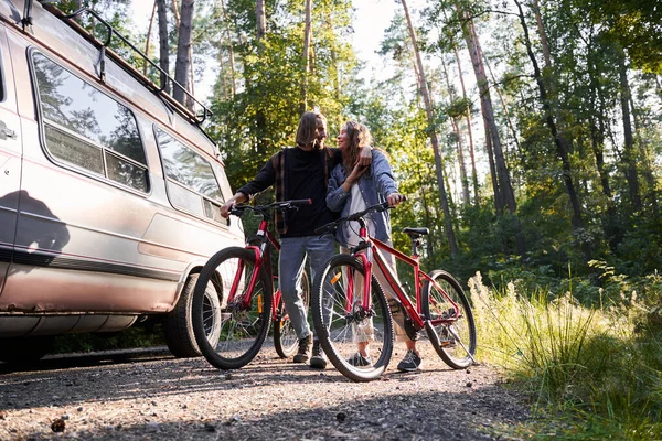 Par omfamning när de står med sina cyklar — Stockfoto