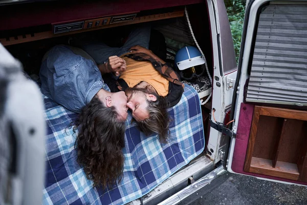 Couple kissing while laying at the trunk — Stock Photo, Image