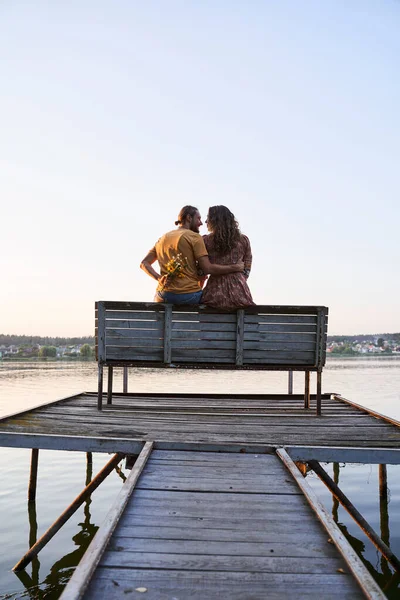 Pár zamilovaný sedí na molu — Stock fotografie