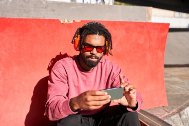 Güneşli sokakta dinlenen bir adam