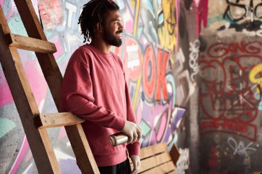 Graffiti yazarı merdivene yaslanmış duruyor.