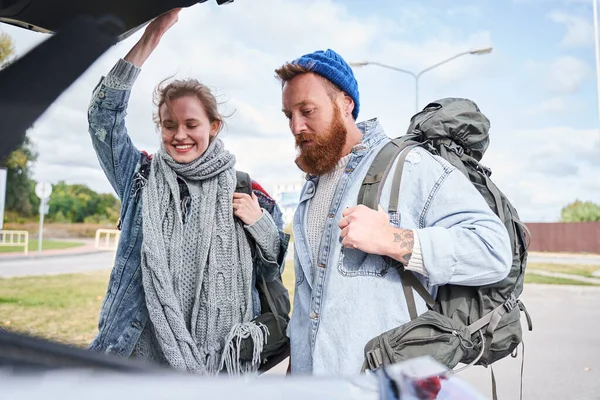 Muž vystupující z kufru auta velký batoh — Stock fotografie