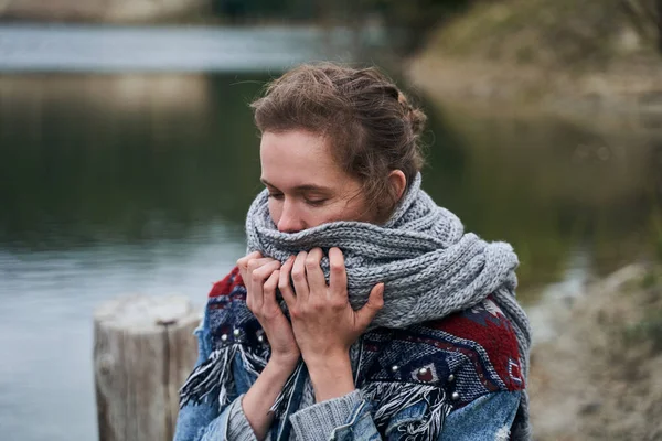 Vrouw kijkt naar beneden naar haar sjaal — Stockfoto