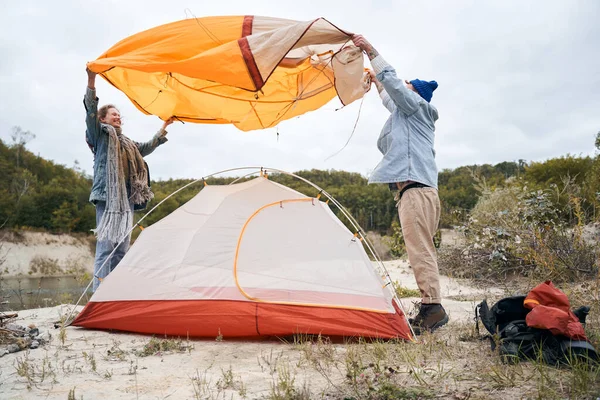 Couple covering tent with protective cover — Stock Photo, Image