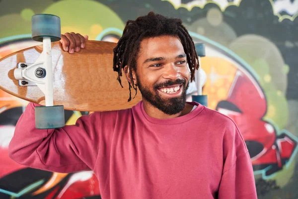 Man staying with wooden skateboard — Stock Photo, Image