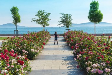 Bostancı sahilinde patenle gezen küçük kız, Prens Adaları manzaralı