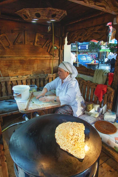 Турецкая женщина катит тесто для приготовления традиционной турецкой выпечки — стоковое фото