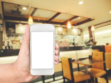 Mobil akıllı telefon kahvehane iç görüntü arka plan üzerinde tutan el