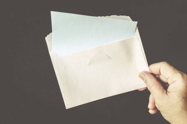 Elini tutmak bir zarf ve kağıt üzerinde siyah arka plan