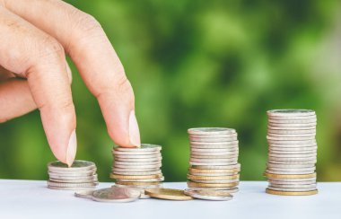 Erkek el adımlar yeşil arka plan üzerinde-büyüyen iş yığını gibi para sikke üzerinde finans ve para kavramı