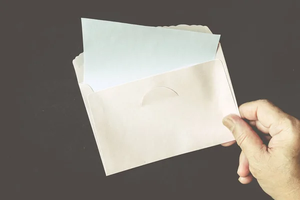 Hand Houden Een Enveloppe Papier Zwarte Achtergrond — Stockfoto