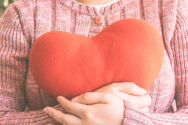 Red heart in woman hands
