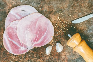 Taş zemin üzerine sarımsaklı dilimlenmiş jambon füme