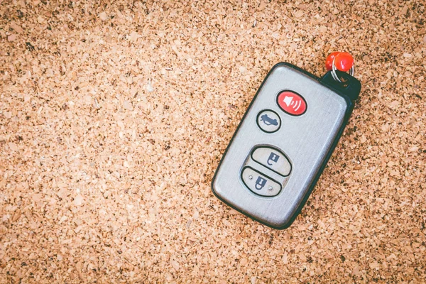 Remote car key on cork board