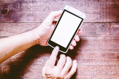 Adam akıllı telefon boş ekran üzerinde ahşap masa tutan eller