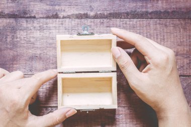 Bir empty(blank) ahşap masa üzerinde ahşap kutuyu açtı ellerini tutun