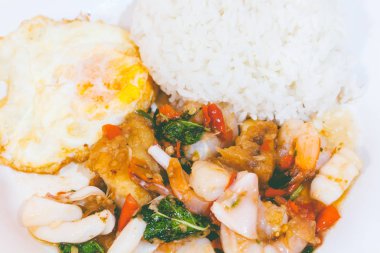 Pirinç tavada kızartılmış kombinasyonu domuz eti, kalamar, karides, fesleğen ve kızarmış yumurta ile tepesinde. Tayland Gıda