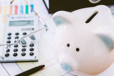 Piggy banka ve hesap makinesi iş belgeleri arka plan üzerinde