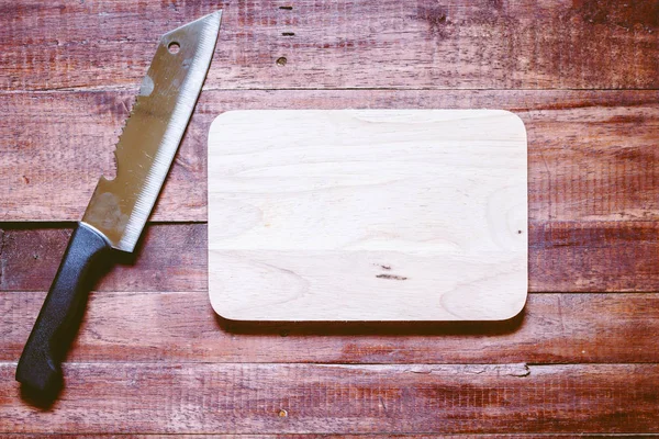 Tahta arka planda bıçak ve kesim tahtası