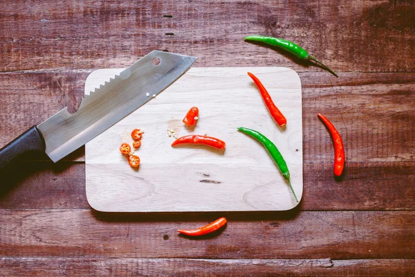 Doğrama Kurulu üzerinde ahşap arka plan üzerinde biber bıçak ile