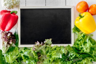 Sağlıklı sebze ve ahşap arka plan siyah kurulu