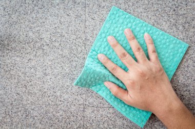 El ve bir duvara temizleme bir mavi bezi