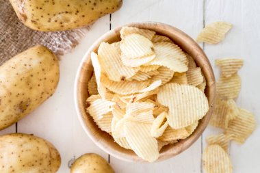 Ahşap masa üzerinde ahşap bir kase gevrek patates cipsi