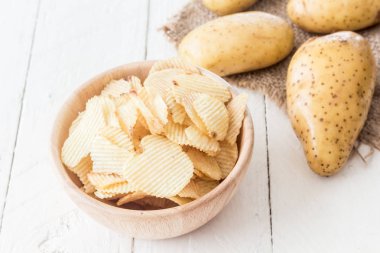 Ahşap masa üzerinde ahşap bir kase gevrek patates cipsi