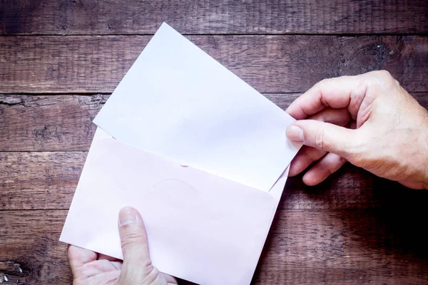 Hand Houden Een Enveloppe Papier Houten Achtergrond — Stockfoto