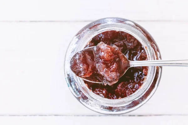 Strawberry jam in a jar on wooden table